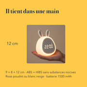 Les dimensions du réveil enfant éducatif veilleuse lapin, tenu dans une main