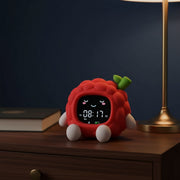 Réveil jour et nuit enfant veilleuse framboise, posé sur une table de nuit